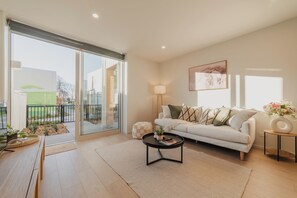 Una sala moderna con sofá, mesa de centro y vistas al exterior.
