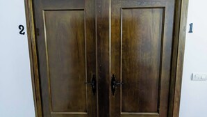 Una puerta doble de madera oscura con dos pomos, marcada con los números 1 y 2 en la pared a su derecha.
