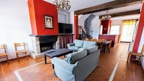 Una sala de estar con chimenea, un sofá y una televisión.