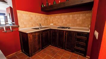 A kitchen with dark wooden cabinets, a white countertop, and a tiled backsplash.
