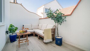 A small outdoor seating area with a sofa, table, and potted plants. - Lower Bouys in the seaside village of Seaview on the Isle of Wight (Seaview)