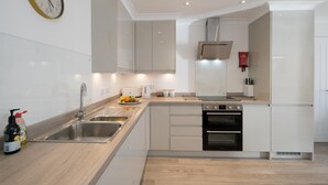 A modern kitchen with a sink, stove, and oven. - Lower Bouys in the seaside village of Seaview on the Isle of Wight (Seaview)