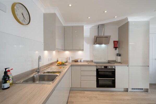 A modern kitchen with a sink, stove, and oven.