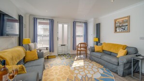 A modern living room with two grey sofas, a patterned rug, and a yellow throw blanket. - Lower Bouys in the seaside village of Seaview on the Isle of Wight (Seaview)