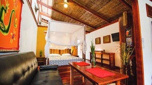 A room with a bed, a sofa, a dining table, and a ceiling fan. - Villa #2 - 1 Bedroom with private Garden (Puerto Viejo de Talamanca)