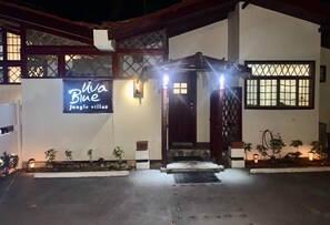 A building with a sign reading 'Viva Blue jungle villas' at night.