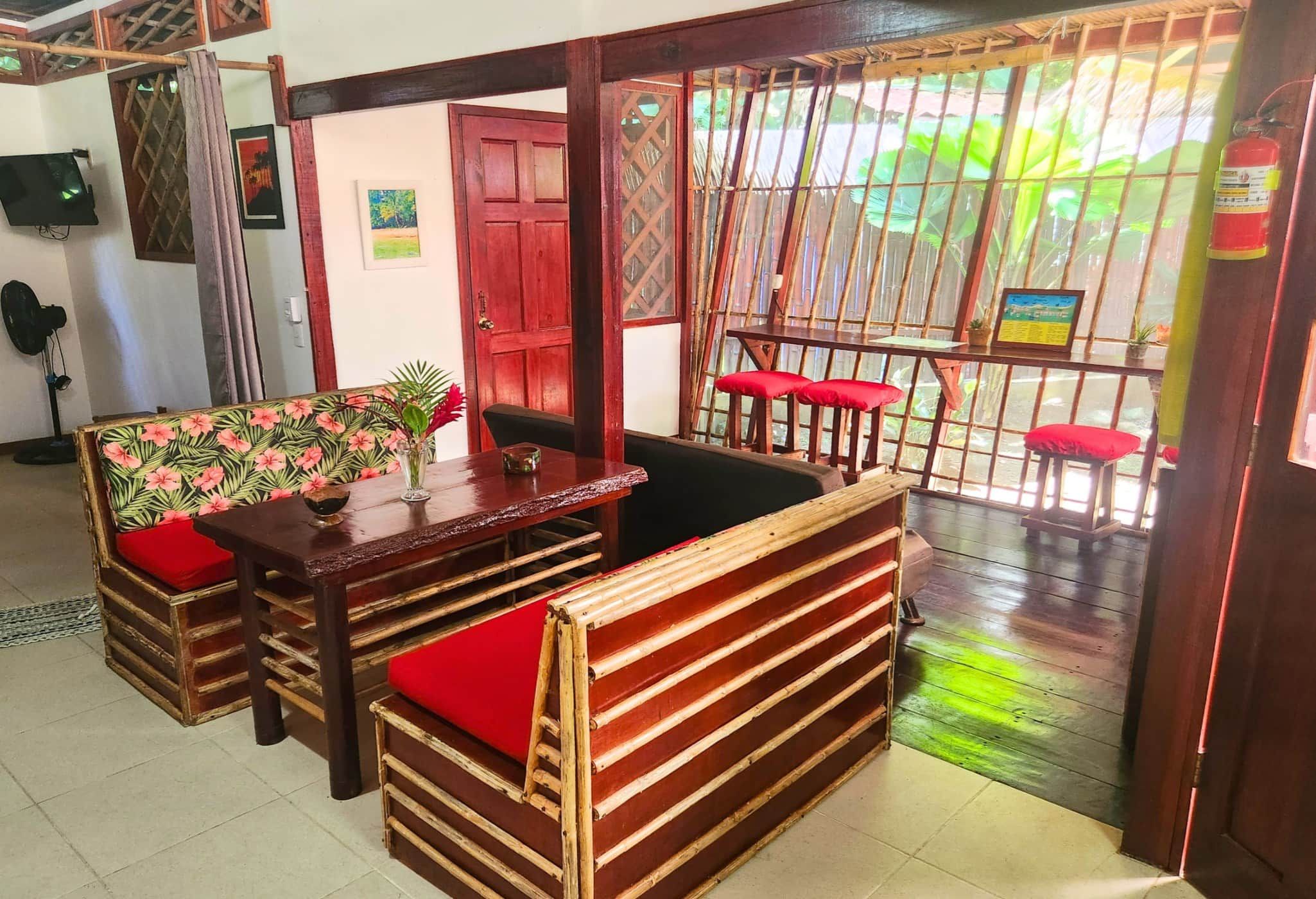 A room with a wooden bench seating area, a table, and a door leading outside.