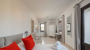 Een hotelkamer met een bed, stoel, bureau en spiegel.