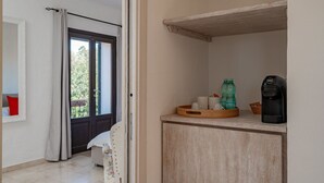 Een kamer met een houten kast, een koffiezetapparaat en een dienblad met bekers en een fles.