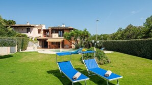 A villa with a swimming pool, two lounge chairs, and a well-maintained lawn. - Villa Aurora - Villasimius Paradise (Villasimius)