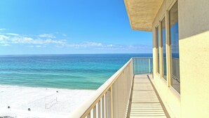 A balcony with a view of a beach and ocean.