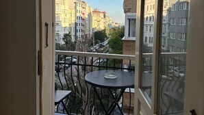 A balcony with a patterned floor, a small round table, and a chair. - Şah Bey Konağı (Istanbul)