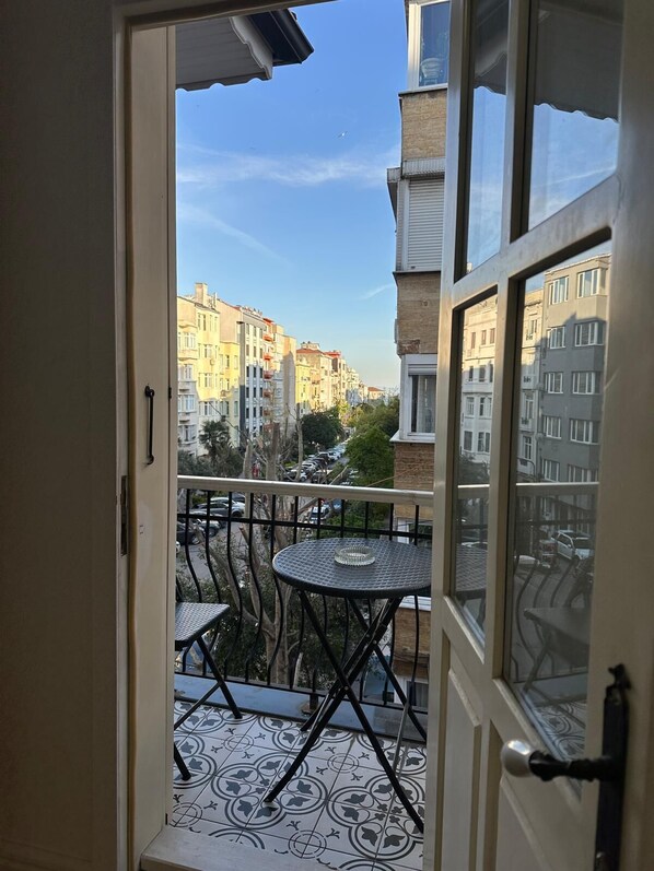 A balcony with a patterned floor, a small round table, and a chair. - Şah Bey Konağı (Istanbul)