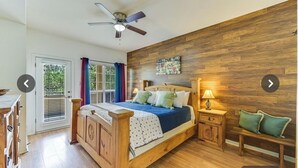 Une chambre avec un lit en bois, une table de chevet avec une lampe, un banc et un mur orné d’une affiche sur laquelle on peut lire le mot « AMOUR ».