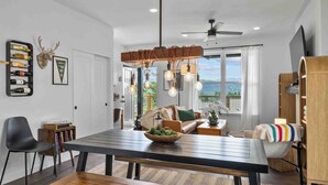 A modern dining area with a wooden table, benches, and a ceiling fan. - Affordable Secret w/ Charm + PetFriendly/Spa/Views (Ronald)