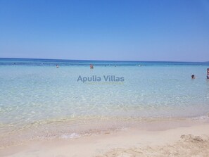A beach with clear water and people swimming. - Cozy Ammamì Vacation Home, 150 m from the Sea, Rivabella di Gallipoli   (Rivabella)