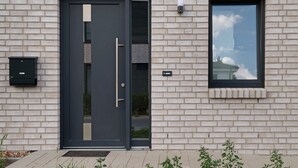 A modern building with a dark door, a small window, and a mailbox on the wall. - Holiday Home 'Das Strandhaus' with Private Terrace, Private Garden and Wi-Fi (Lembruch)