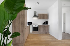 Eine moderne Küche mit Holzschränken, einem Einbauofen und einer Edelstahl-Dunstabzugshaube.