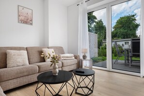 Un salon moderne avec un canapé, une table basse et une télécommande.