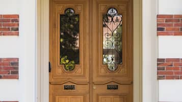 Dos puertas de madera con paneles de vidrio decorativo y una pequeña placa debajo de cada puerta.