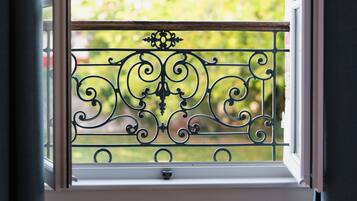 A window with a decorative metal grille.
