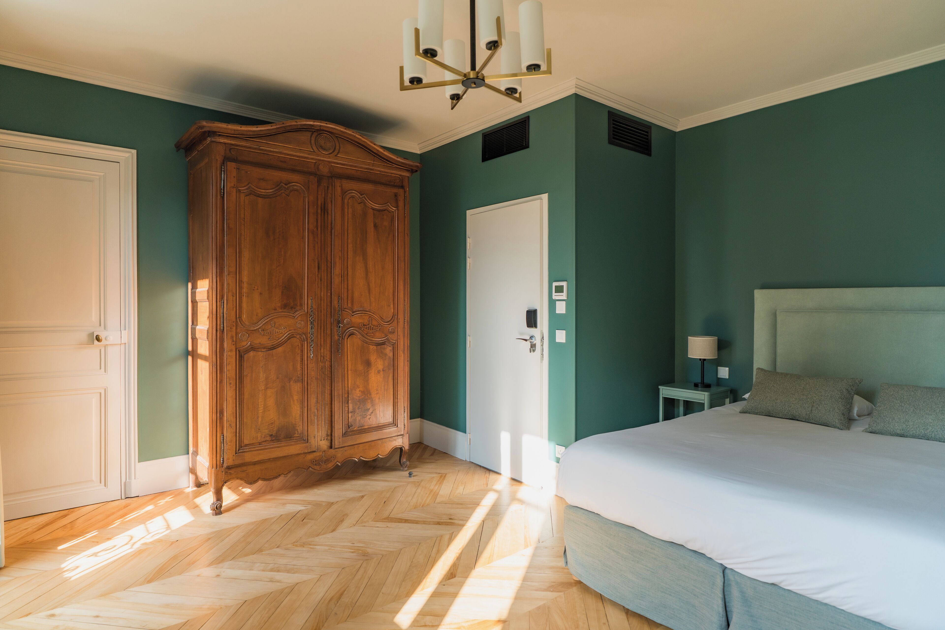 A bedroom with a large bed, a wardrobe, and a door.