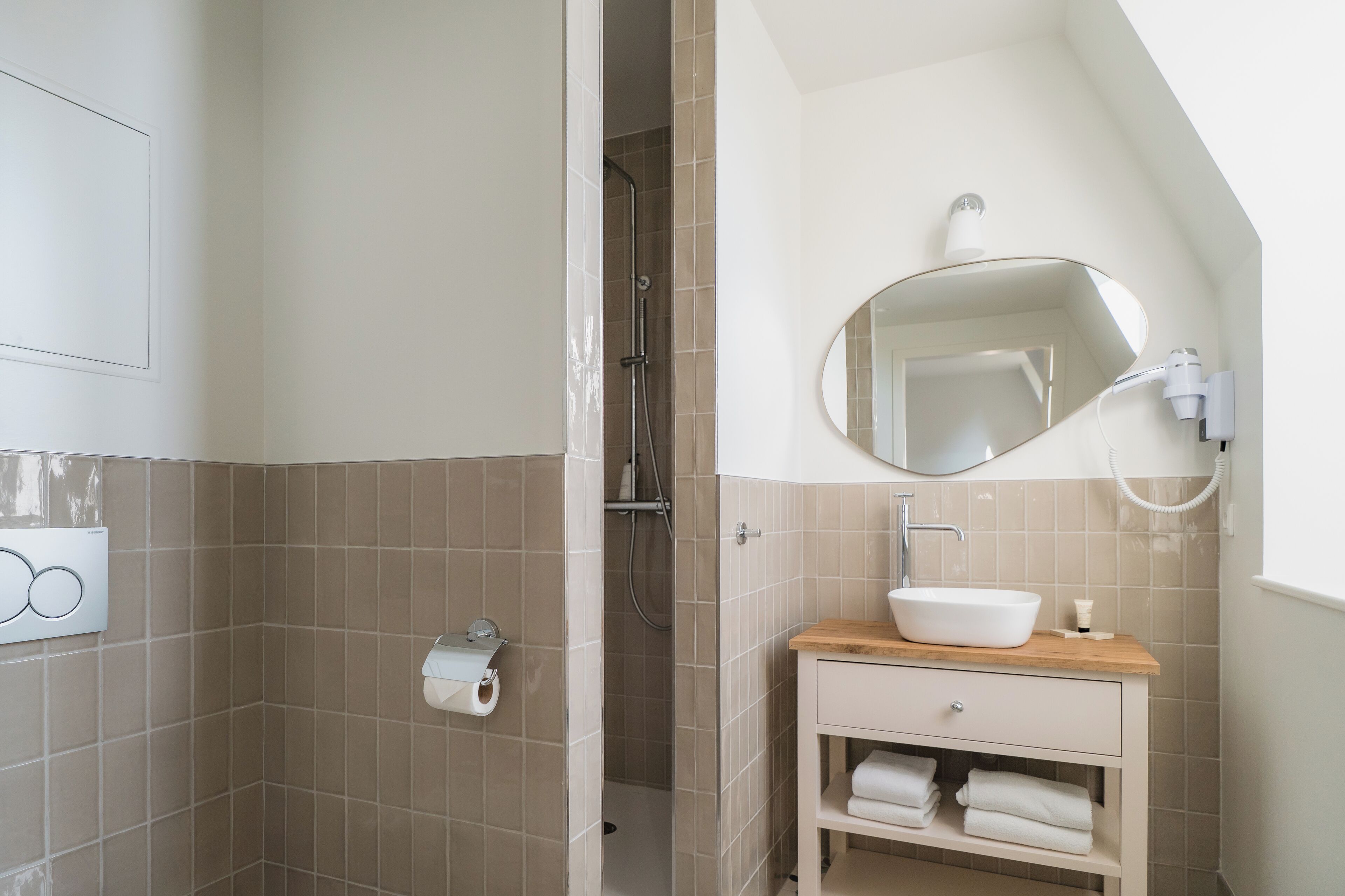A bathroom with a shower, a sink with a mirror, and a towel rack.