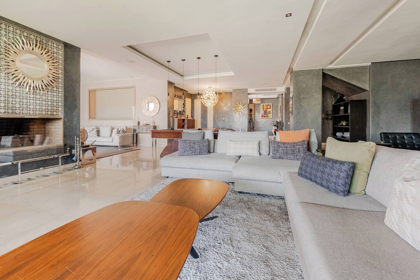 Ein modernes Wohnzimmer mit Sofa, Couchtisch und Kamin.