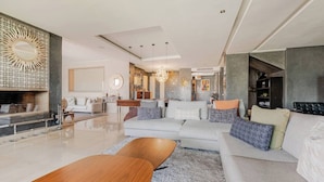 A modern living room with a sofa, coffee table, and fireplace.