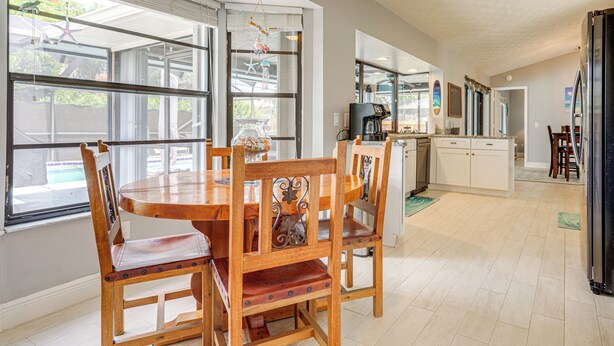 A spacious kitchen with a dining area, large windows, and a view of the outdoors.
