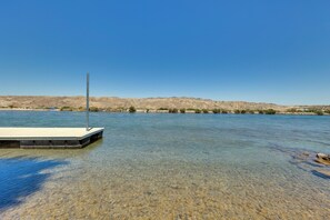A clear lake with a dock extending into the water.