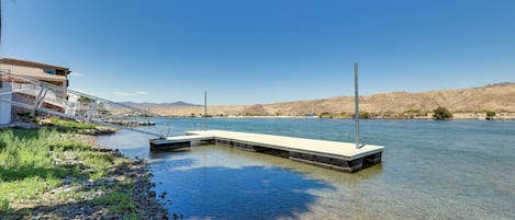 A riverside dock with a building adjacent to it.