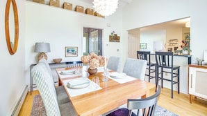 Un comedor con una mesa de madera, sillas y una lámpara colgante.