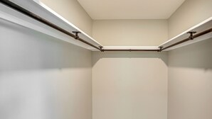 Un placard d’angle avec des murs blancs et un plancher en bois.