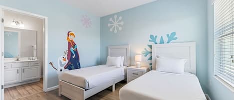 A bedroom with two beds, a nightstand, a dresser, and a bathroom with a mirror.