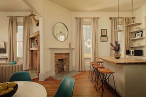Una cocina moderna con chimenea, taburetes de bar y una zona de comedor con mesa y sillas.