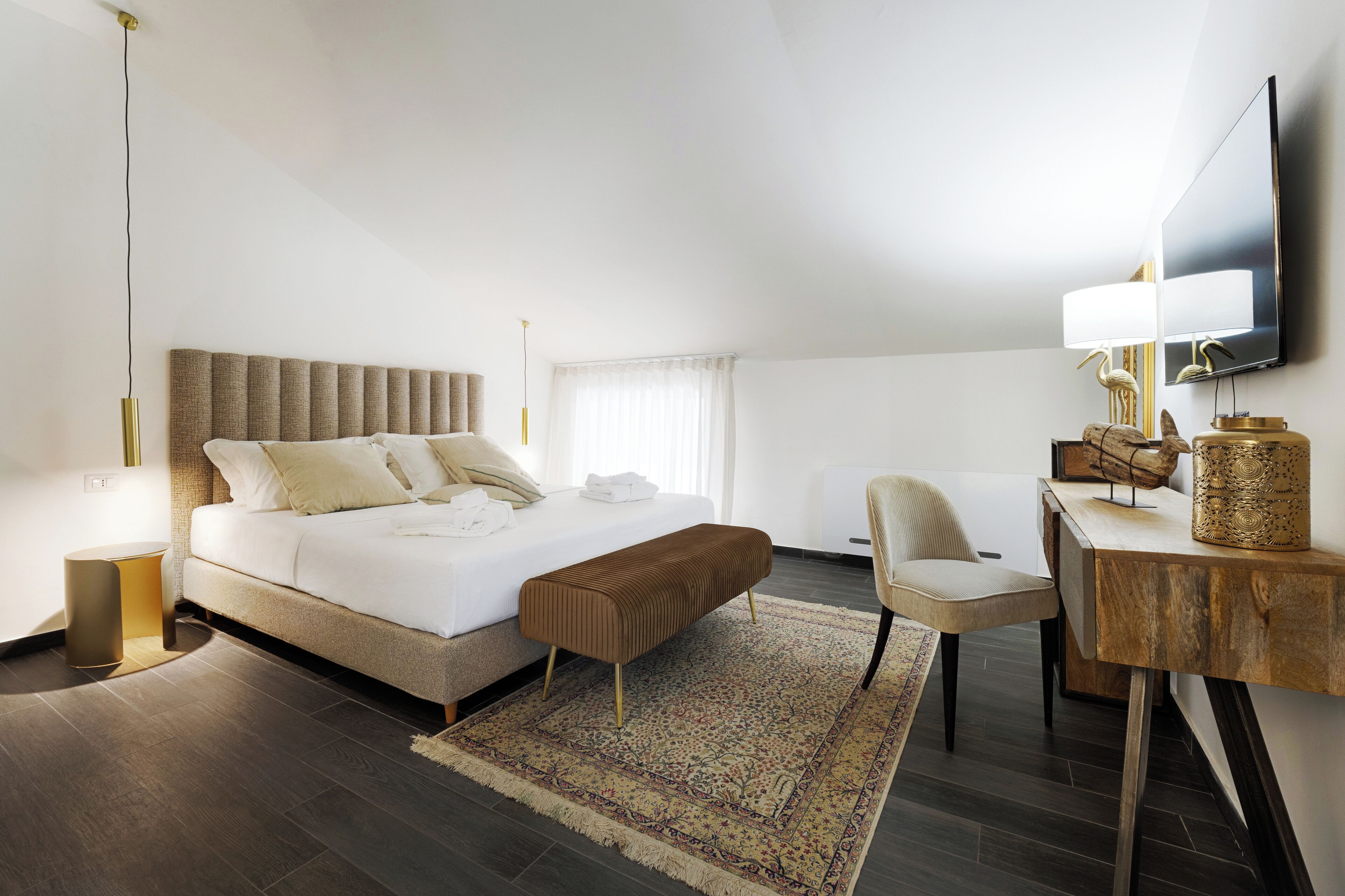 Habitación de hotel moderna con una cama grande, un escritorio, una silla y una televisión.