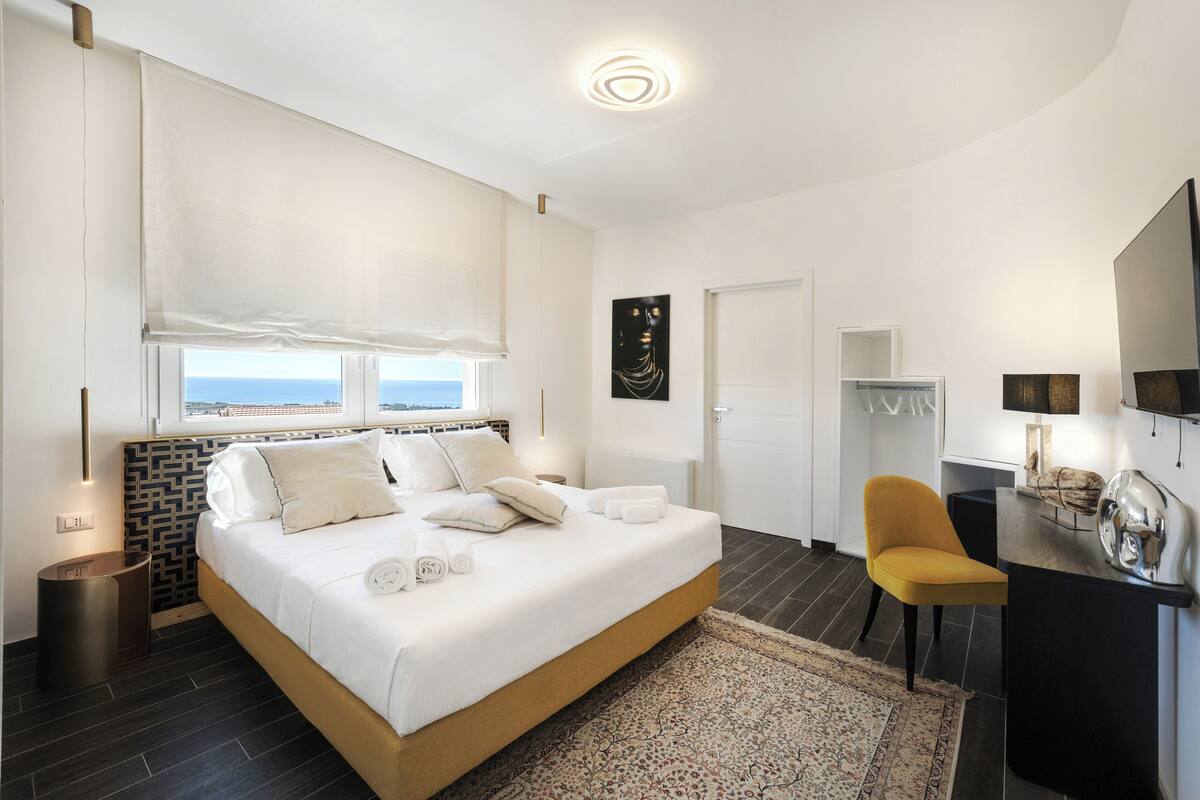 Una camera da letto moderna con un letto grande, una scrivania e una sedia.