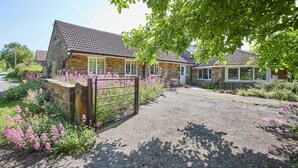 A stone building with a gravel driveway and a metal gate. - Host & Stay | Lane Farm Cottage (Easington)