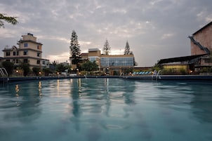 Una piscina con agua cristalina que refleja edificios y árboles circundantes.
