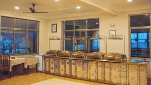 A spacious room with a long counter, large windows, and a ceiling fan.