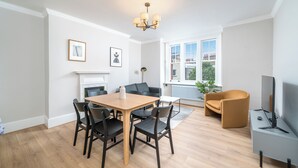 Un salon moderne comprenant un coin repas, une cheminée, un canapé et un téléviseur.