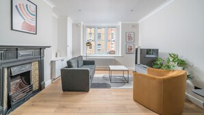 Un salon moderne avec une cheminée, un canapé, une table basse et une plante.