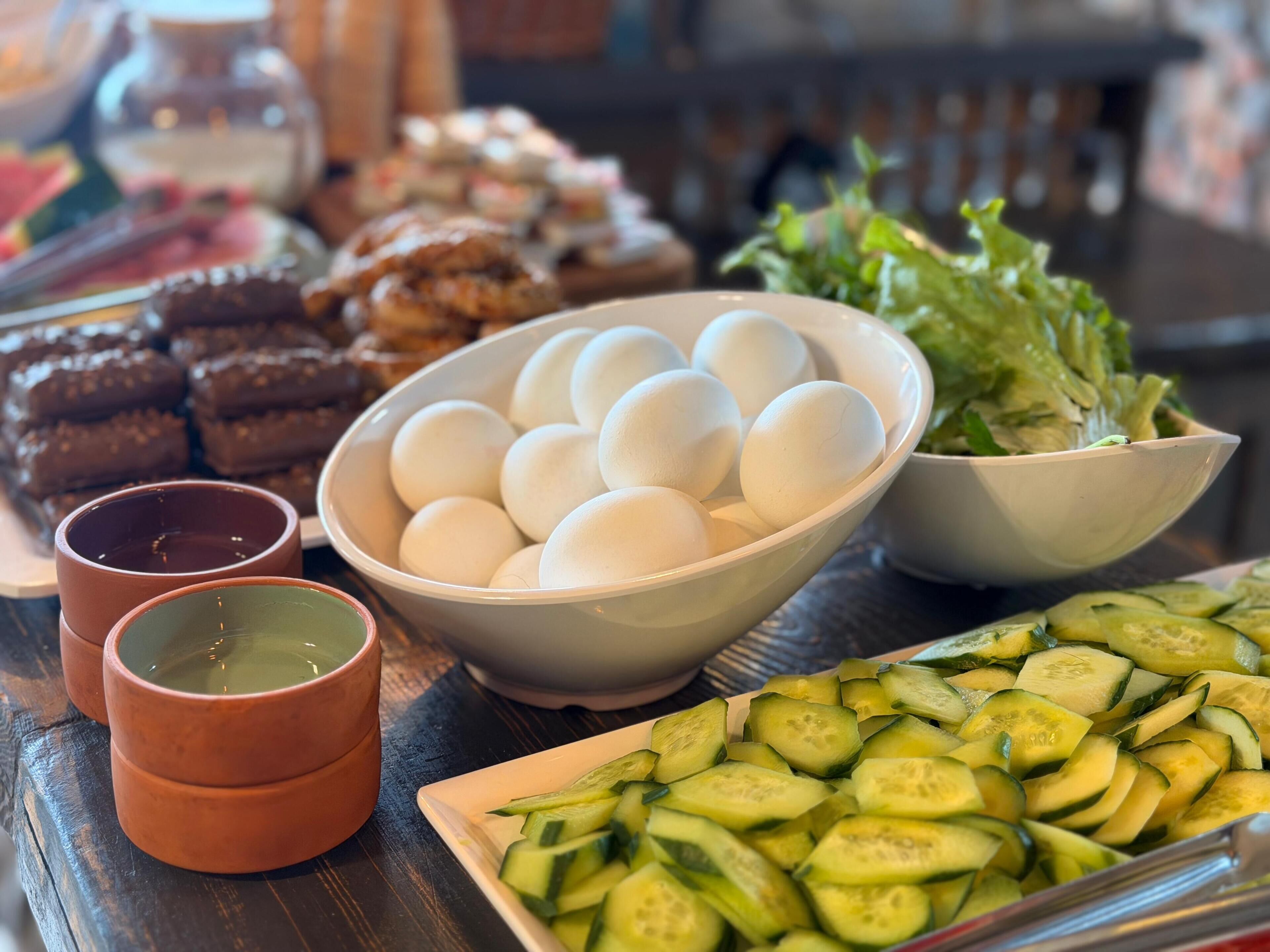 A table with various food items including eggs, cucumbers, and baked goods.