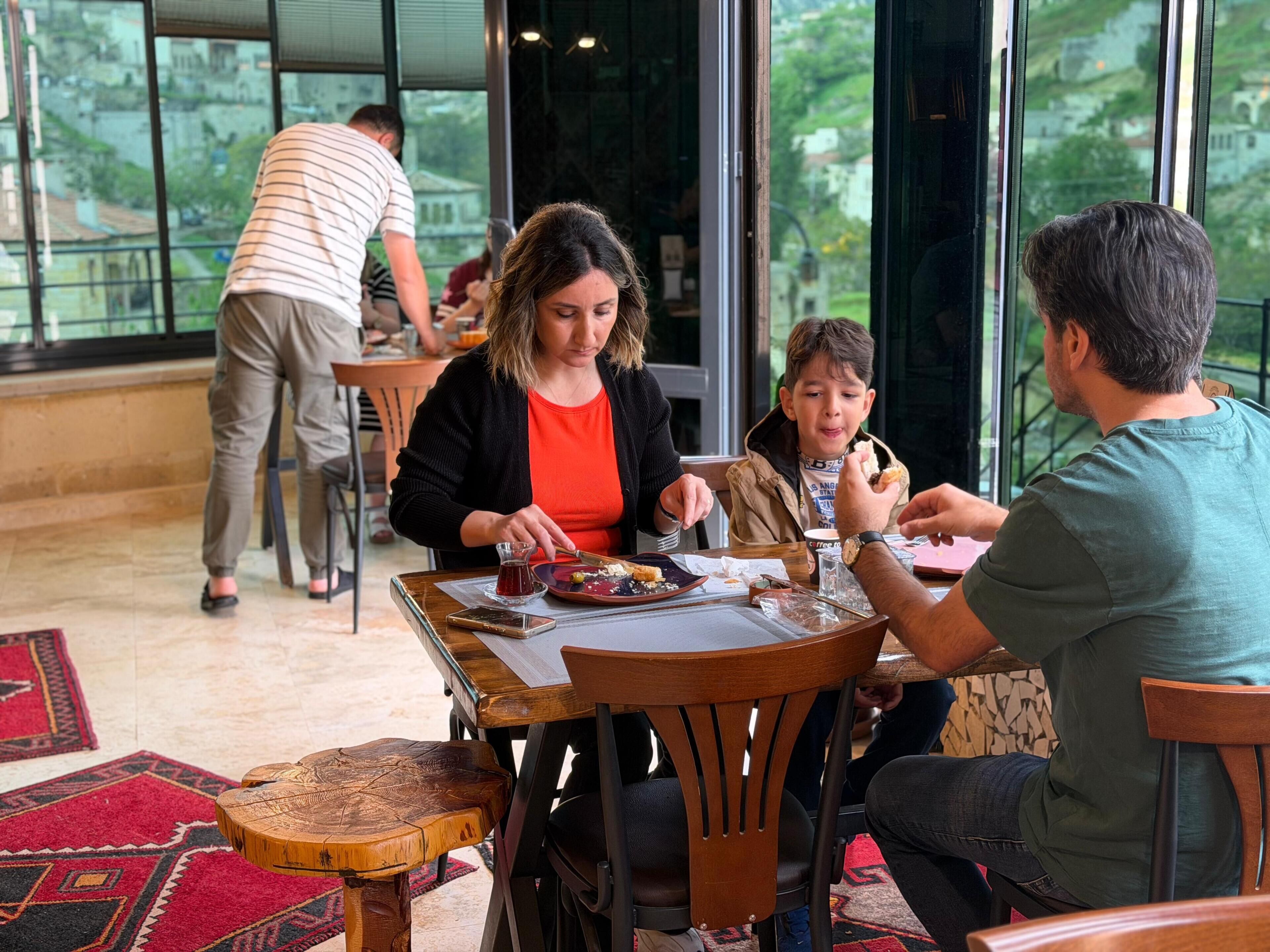 Un restaurante con terraza, amplios ventanales y vistas del entorno.