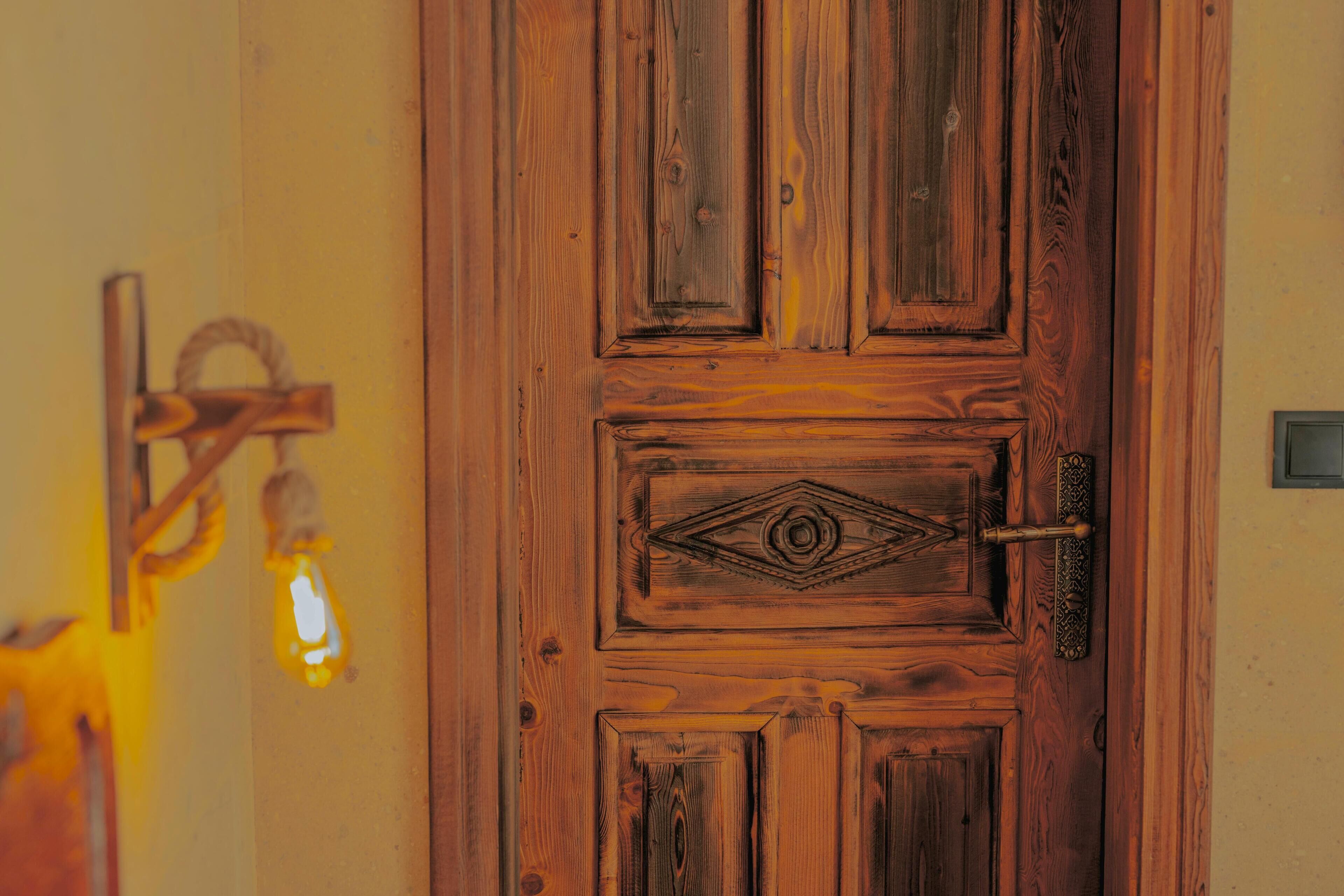 Una puerta de madera con un diseño de diamantes decorativo y un tirador de latón.