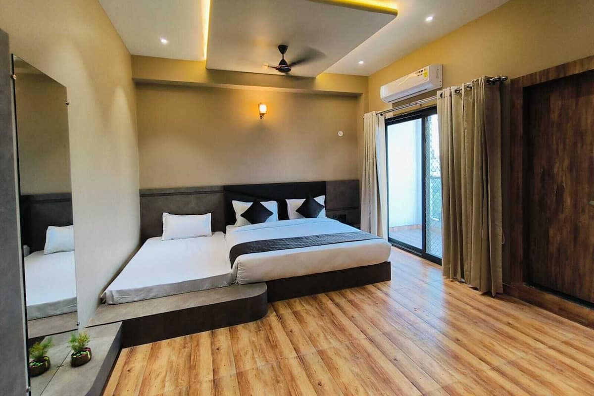 Ein modernes Schlafzimmer mit einem großen Bett, einem Deckenventilator und einer Klimaanlage.