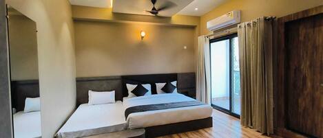 Un dormitorio moderno con una cama grande, un ventilador de techo y un equipo de aire acondicionado.