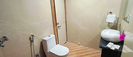 A bathroom with a toilet, sink, and mirror.