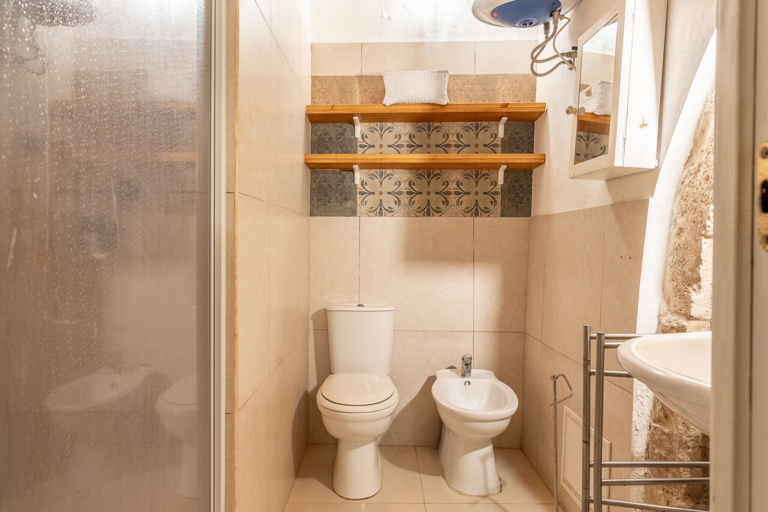 Ein kleines Badezimmer mit Toilette, Bidet und Waschbecken.
